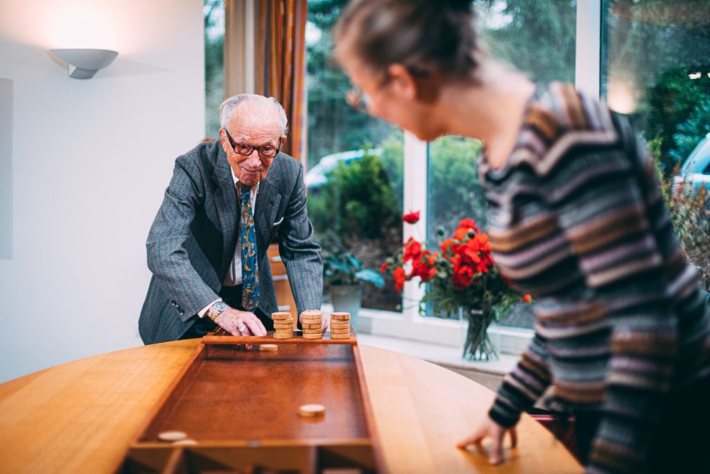 Een bewoner en een medewerker kijken samen naar Familienet